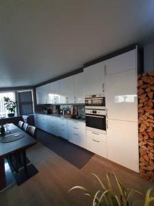 腓特烈斯塔Modern loftsleilighet的厨房配有白色橱柜和桌子