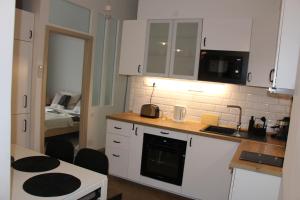 布达佩斯Larix apartman的厨房配有白色橱柜和台面
