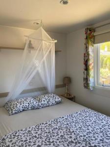塔里法Cozy cottage in nature, with Garden and Sea View & Fast 350mbps Wi-Fi的一间卧室配有一张带天蓬和窗户的床