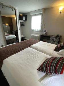 里摩日Kyriad Direct Limoges Nord的配有一张大床和镜子的酒店客房