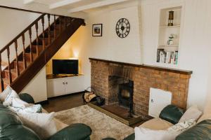 卡斯尔顿CLIFFE COTTAGE - Countryside Cottage in Castleton, Peak District National Park的客厅设有壁炉和墙上的时钟