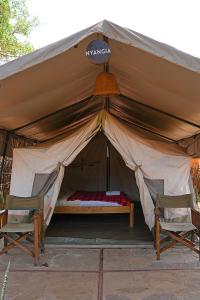 MorotoKara-Tunga Safari Camp的帐篷配有两把椅子和一张床