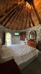 斯库台Windmill Shkodra Gesthouse Camping & Grill的石头建筑中一间带大床的卧室