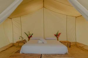 伯里塔卡Manoush Beach的一间帐篷内带白色床的卧室