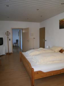 瓦尔德布龙施特劳斯酒店的一间卧室配有一张带白色床单的大床