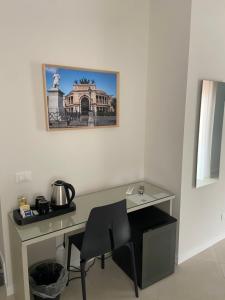 巴勒莫Maqueda Suites的一张桌子、椅子和墙上的照片