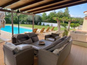 Áyios YeóryiosRelaxing Villa with Swimming Pool and Garden的一个带桌椅的庭院和一个游泳池