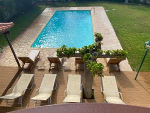 Áyios YeóryiosRelaxing Villa with Swimming Pool and Garden的一个带椅子和桌子的游泳池