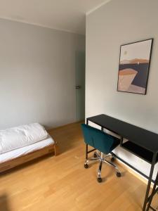 卑尔根Bayern Lodge Bergen的一间卧室配有一张床、一张桌子和一把椅子