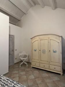 马达莱纳Appartamento il Caracolo a Cala Francese的一间卧室配有大型木制橱柜和椅子