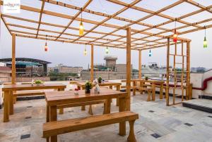阿格拉HOT - House Of Travellers Taj view的屋顶上设有木桌和长凳的凉亭