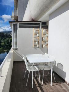 比索达雷加Janela D’Ouro的阳台配有白色桌子和白色椅子