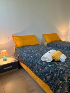 BeccacivettaLe Colombe的一间卧室配有两张带黄色枕头的床
