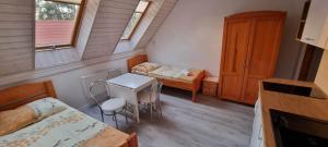 波别罗沃波德扎格拉米酒店的小房间设有一张床、一张桌子和椅子