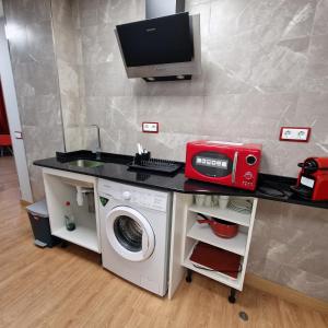 托莱多Gavilanes 2 TOLEDO的厨房配有洗衣机和台面上的电脑