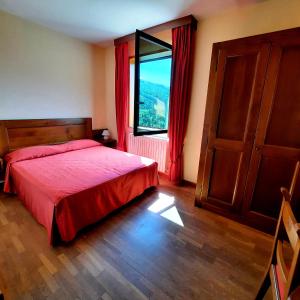 阿贝托内贝拉维斯塔酒店的一间卧室设有红色的床和窗户。