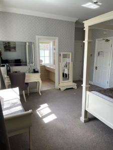 莱德沙姆英格伍德庄园酒店的一间卧室设有1间带浴缸和镜子的浴室