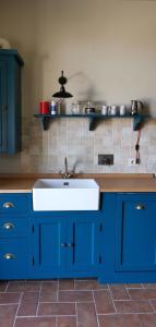 渥尔特拉Podere Campiano的厨房配有蓝色橱柜和白色水槽