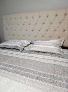 马瑙斯Casa Linda e Aconchegante的一张带白色床架和两个枕头的床