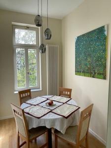 莱比锡Ruhige&charmante Altbauwohnung的餐桌、椅子和墙上的绘画