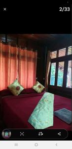 卡塔海滩Thai authentic wooden house at Kata的一间卧室设有两张带红色床单和窗户的床。