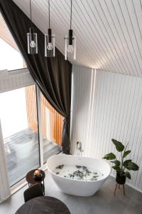 马多纳Sniegi design cabin with sauna的一间带浴缸的浴室,位于一个窗口的房间
