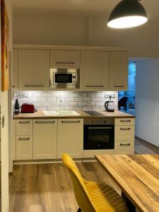 克塞洛Corner Apartman的厨房配有白色橱柜和木桌