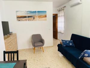 科尼尔-德拉弗龙特拉Apartamento Conil Playa & Centro, perfecto descanso, con Aire Acond y WIFI的客厅配有蓝色的沙发和椅子