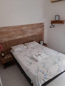 塞蒂拉瓜斯Kitnet - Apart Hotel 3的一间卧室配有一张带木制床头板的床