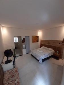 塞蒂拉瓜斯Kitnet - Apart Hotel 3的一间卧室配有一张床、一张桌子和一张沙发