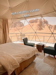 瓦迪拉姆RUM CHEERFUL lUXURY CAMP的美景帐篷内的一张床和两把椅子