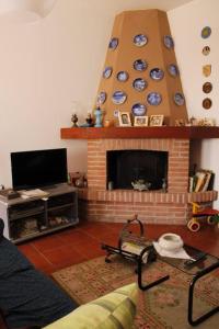 Rivalta ScriviaDa Mariuccia的客厅设有壁炉和电视。