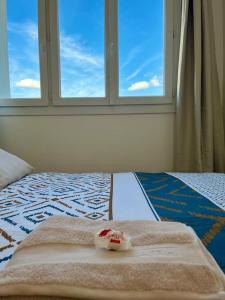 维勒班Chambre privée dans un appartement partagé的一张带两条毛巾的床和窗户