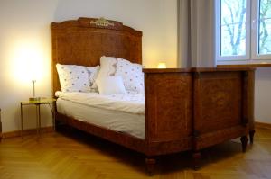 普瓦维Meta Biblioteka的一间卧室配有一张带木制床头板的床