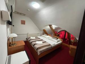 埃格尔Hotel Minaret&Étterem的小房间设有床铺和电视