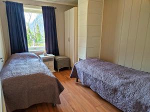 艾于兰Otnes Fjordside的一间卧室设有两张床和窗户。