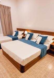 Felidhoo Vaagali Inn的蓝色和白色的客房内的两张床