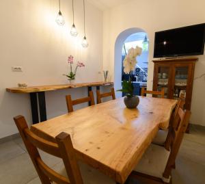波尔图·埃尔科莱Marina House Porto Ercole的一间带木桌和椅子的用餐室