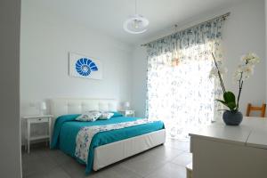 波尔图·埃尔科莱Marina House Porto Ercole的一间卧室设有蓝色的床和窗户。