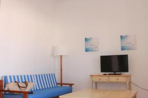 桑帕克Apartamentos Las Pérgolas的客厅配有蓝色的沙发和电视