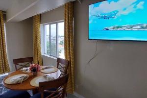 拿骚Nassau Harbour Cozy 2 bedroom Condo的一间设有桌子的用餐室和墙上的电视