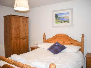 ValtosTaigh Na Beadan的卧室配有白色的床和木制床头板
