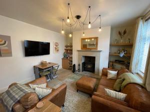 OxenhopeApple Street Cottage的带沙发、电视和壁炉的客厅