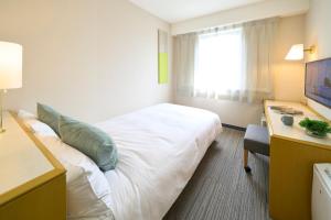 町田市町田市利索尔酒店的酒店客房设有一张大床和一张书桌。