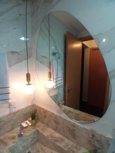 戈亚尼亚Condomínio encantador de luxo的一间带大镜子和盥洗盆的浴室