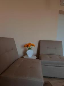 罗镇Rhospitality - Visconti Affittacamere的客厅配有沙发和鲜花花瓶