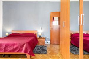 圣欧费米亚拉默齐亚casa Gabriella的一间卧室设有两张带红色床单的床和一扇门