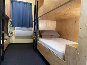 福克斯冰川Fox Glacier Jade Hotel的一间卧室设有两张双层床和一扇窗户。