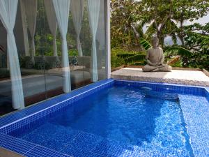 泰泰The Dream Beach Resort的坐在游泳池旁的佛像
