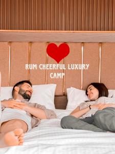 瓦迪拉姆RUM CHEERFUL lUXURY CAMP的躺在床上的男人和女人